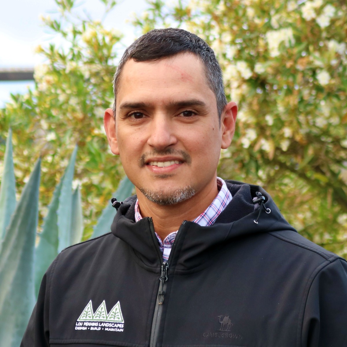 Erick Roldan, Penning Landscapes maintenance account manager, smiling in a garden setting.