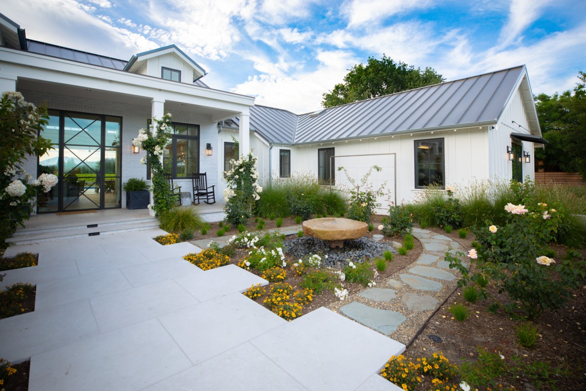Custom Napa Valley landscape design featuring roses, wildflowers, and stone walkways around a modern home.