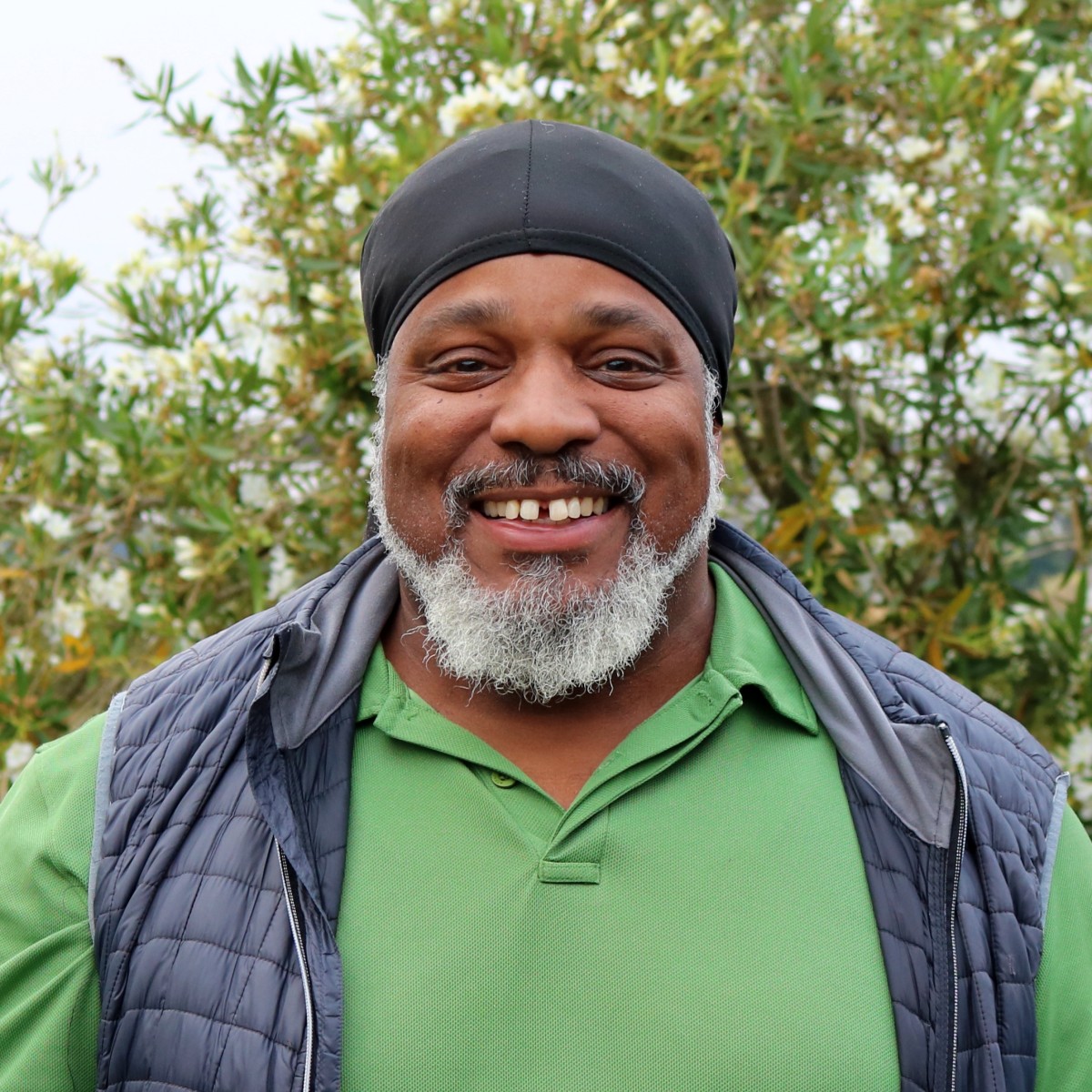 Sha-Khan Starks, Lead Installation Manager at Penning Landscapes, smiling among greenery.