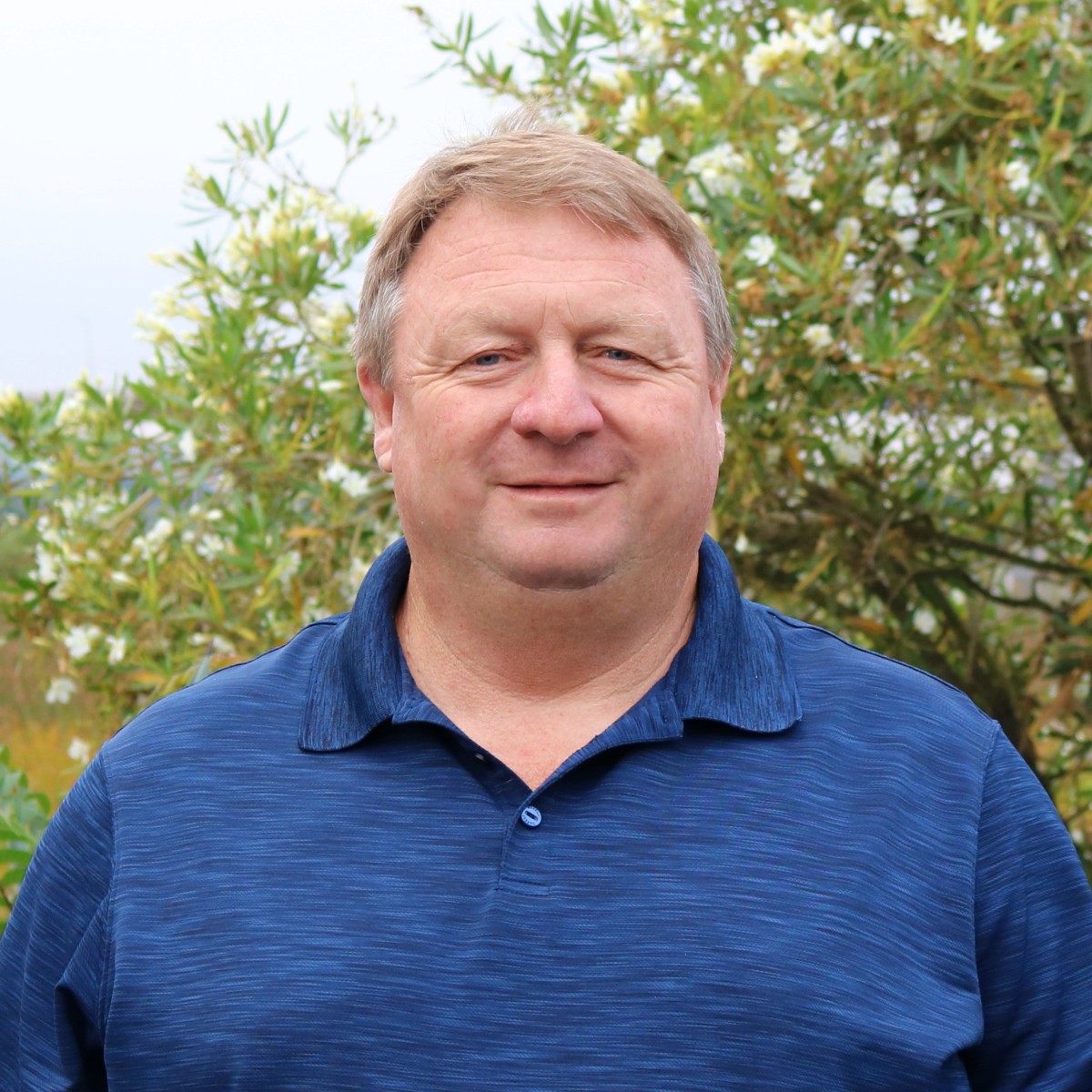 Steve Cole, Penning Landscapes maintenance account manager, in front of flowering shrubs.
