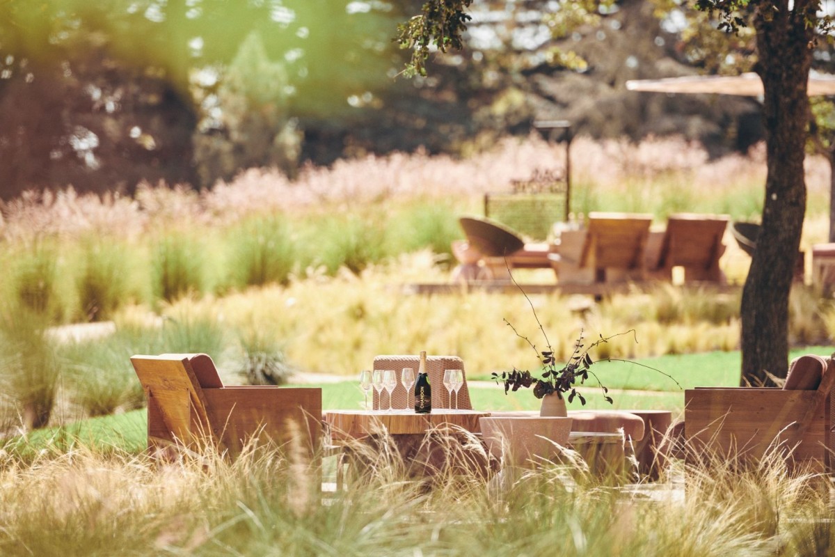 Winery tasting area with seating and plantings, showcasing Penning Landscapes’ grounds care.